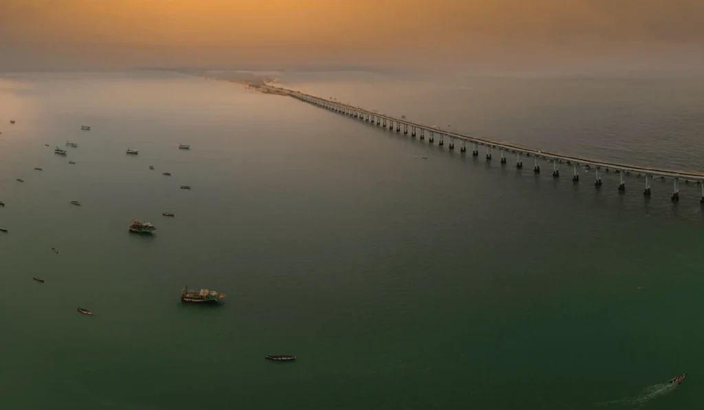 The Pamban bridge running out across the sea at Rameswaram at dawn, fishing boats below